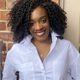 Author Taayoo Murray, African American woman with black curly hair in white shirt