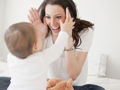 mother playing peek a boo with infant