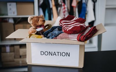 Box labeled donation full of kids clothes and toys