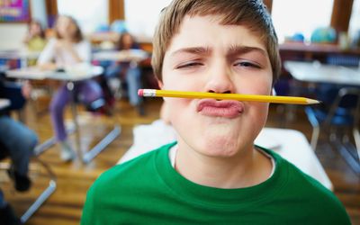 一个男孩在课堂上玩铅笔。
