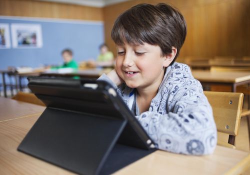 快乐的男生在教室里看平板电脑