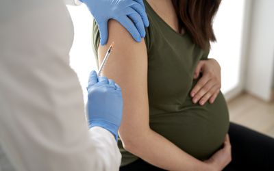 Pregnant person being administered vaccine