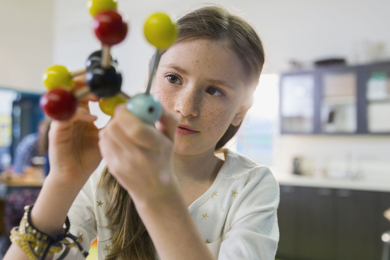 A student examining a molecule model.