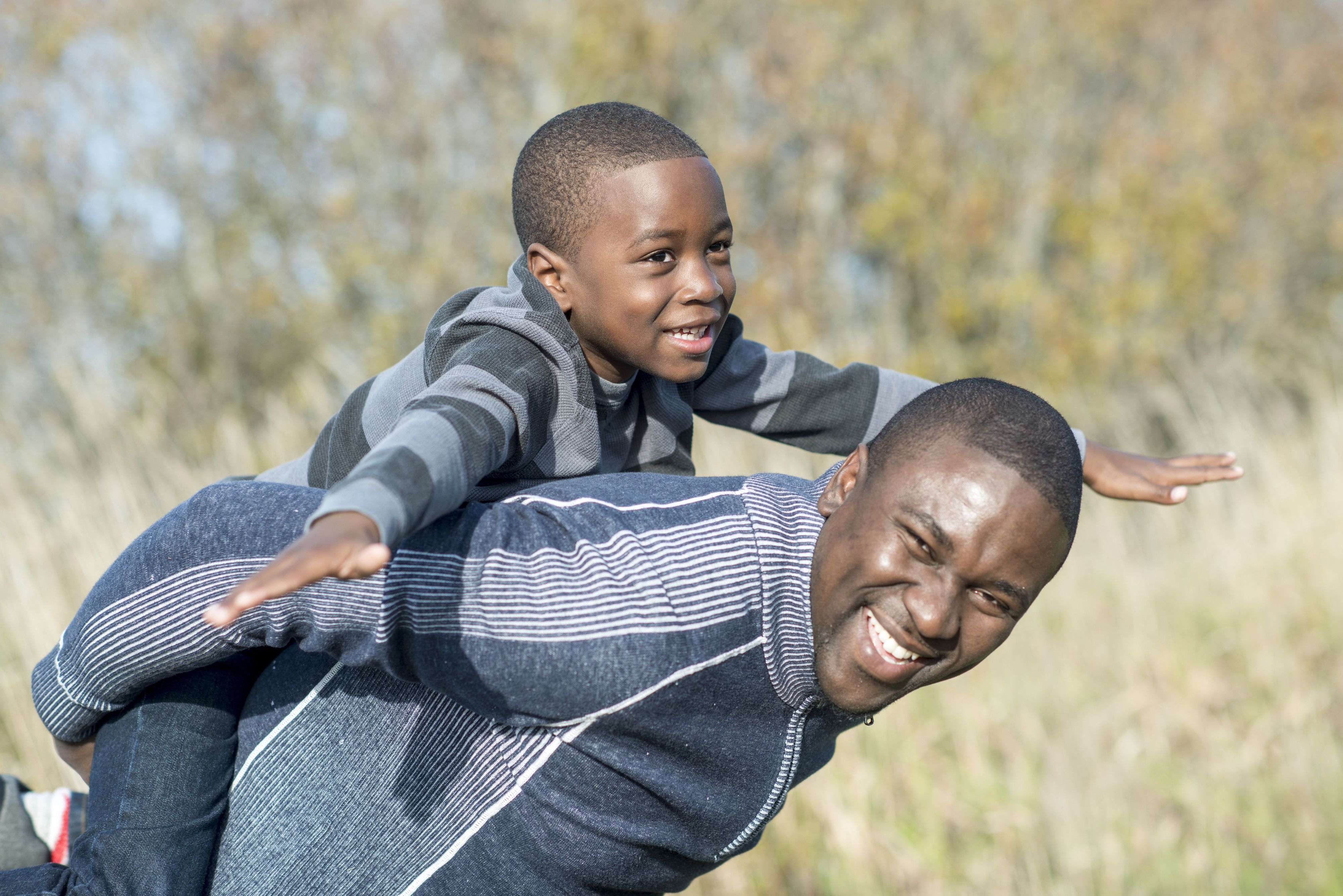 Father and son playing airplane game＂width=