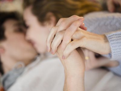 Couple holding hands while kissing