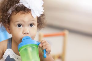 Baby girl drinking from sippy cup