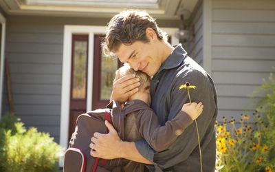 Father Hugging Son With Daisy Before School.＂width=