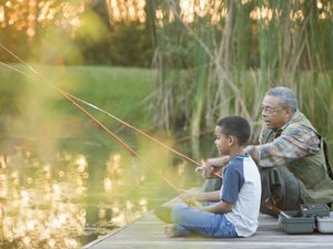 Grandfather and grandson fishing on pier