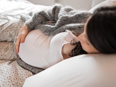 Pregnant woman lying on bed