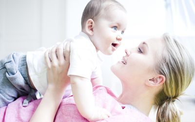 Teenage girl holding baby boy, close up.