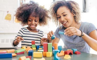 A mom and daughter playing with blocks