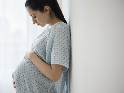 Pregnant woman holding her belly in hospital