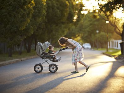 母子推着婴儿车在夕阳下散步