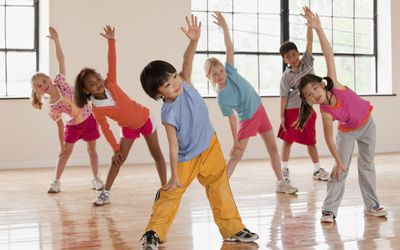 a group of six kids performing dynamic stretches