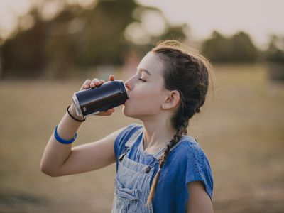 Tween girl drinking a carbonated water