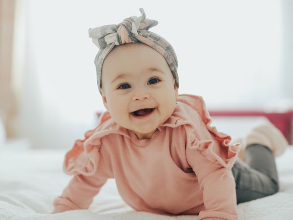 Baby pushing up on a bed