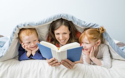 一位母亲正在给一对爱尔兰双胞胎男孩和女孩读书