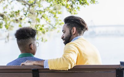 parent and child sitting on a bench and talking