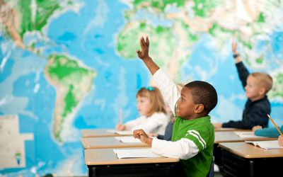 kids raising hands in a first grade classroom