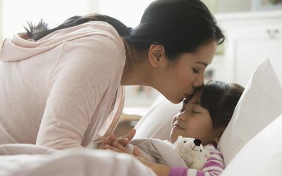 亚洲母亲在床上安慰女儿。