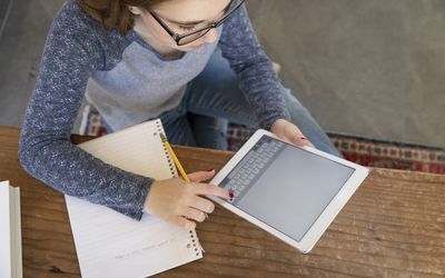 十几岁的女孩用平板电脑做笔记