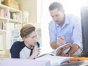 Father helping son with schoolwork