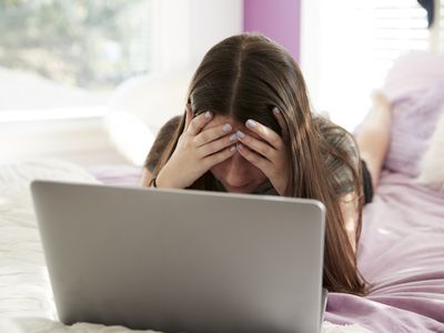 Upset teen using laptop