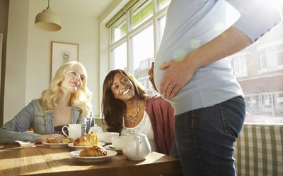 女人羡慕朋友怀孕的肚子。