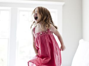 Daughter jumping and screaming on bed