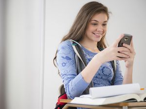 青少年在课桌上使用手机