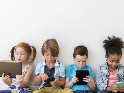 screen time - kids sitting with electronic devices ignoring each other