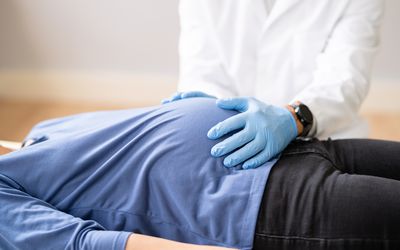 Pregnant woman has her belly examined by a doctor