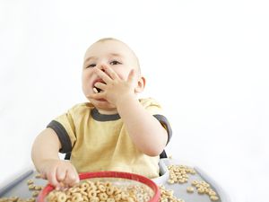 小男孩坐在高脚椅上吃麦片