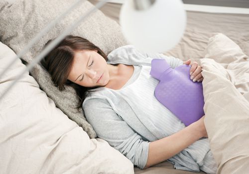 Woman sleeping with a hot water bottle