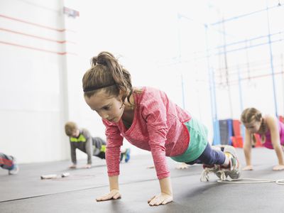 Strength training for kids - girl in gym holding plank position