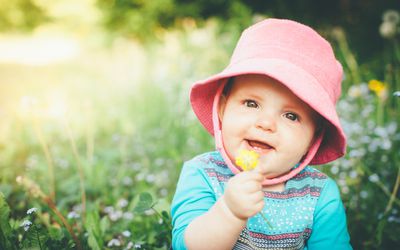 baby girl with bucket hat and flower