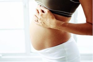 一个孕妇的腹部特写＂width=