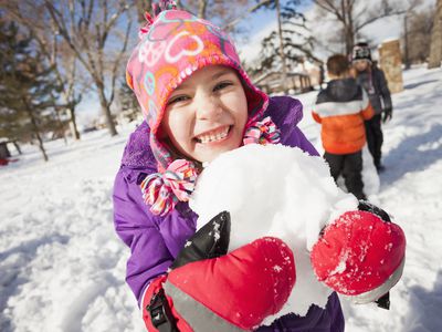 Snow play ideas - girl holding snowball outdoors