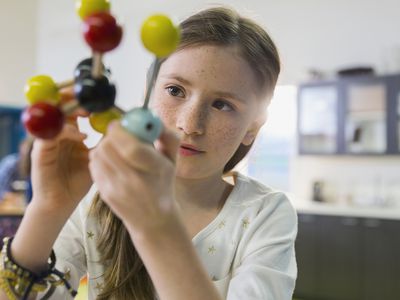 A student examining a molecule model.