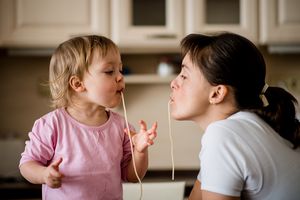 Mother and toddler slurping spagetti