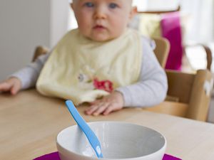 女婴盯着空碗和空勺子