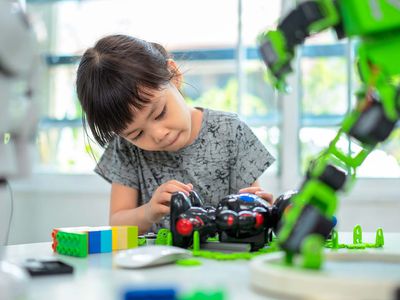 Child builds and analyzing robotic parts while working in school