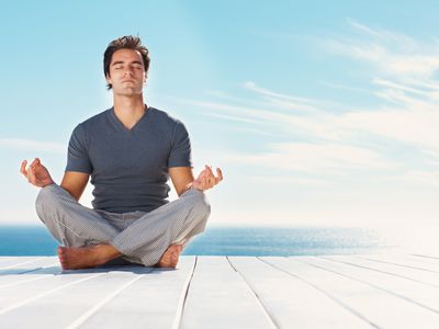 Man sitting on a dock by a lake