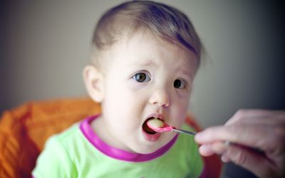 婴儿在吃苹果酱和肉桂