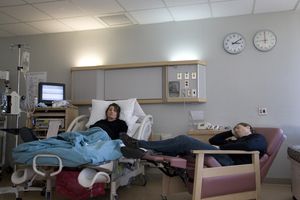 pregnant woman in hospital bed and man sleeping in recliner