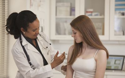 A teenager getting caught up on her vaccines.