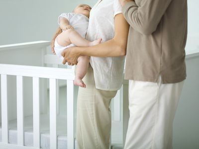 Parents hanging out next to their baby's crib