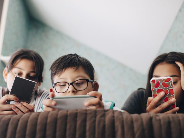 Three kids using smart phones