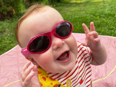 Baby wearing 100% UV protection sunglasses with a strap