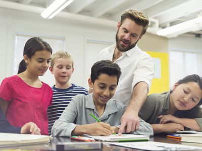 老师和学生们看着一个同学在学校取得成功。